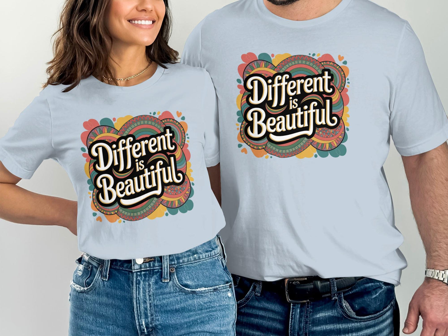 Smiling couple wearing matching light blue t-shirts with a bold retro design that says “Different is Beautiful.” The colorful graphic features hearts and swirls in teal, orange, pink, and yellow. This custom graphic print is a colorful design tee and positive message top that makes a bold shirt statement. Perfect as a self love t shirt, inspirational shirt, or emotional shirt. A unique statement tee and beautiful shirt for anyone who loves a stand out shirt with a positive quote.