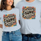 Smiling couple wearing matching light blue t-shirts with a bold retro design that says “Different is Beautiful.” The colorful graphic features hearts and swirls in teal, orange, pink, and yellow. This custom graphic print is a colorful design tee and positive message top that makes a bold shirt statement. Perfect as a self love t shirt, inspirational shirt, or emotional shirt. A unique statement tee and beautiful shirt for anyone who loves a stand out shirt with a positive quote.